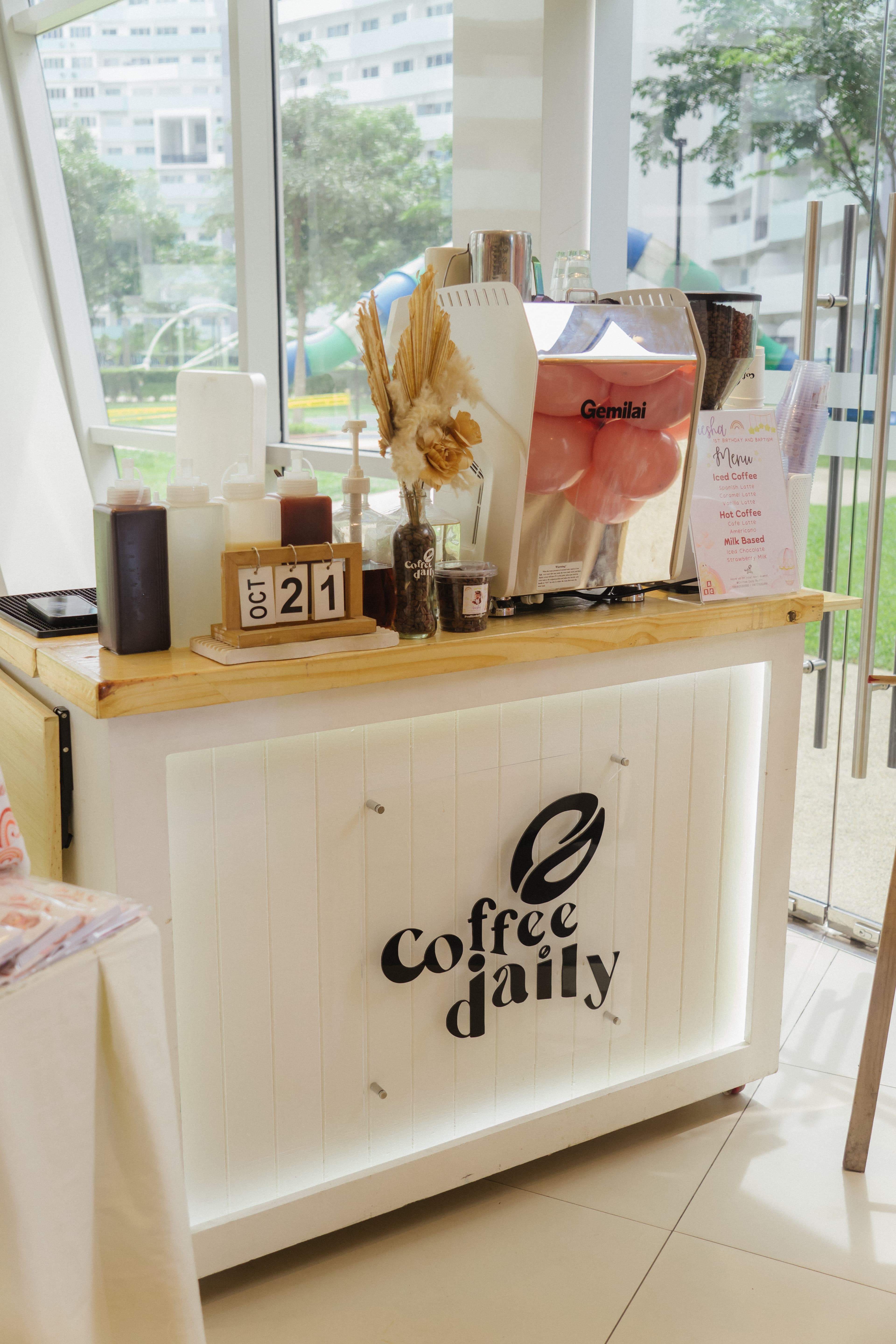 White Coffee Daily mobile cart with an espresso machine filled with pink balloons.